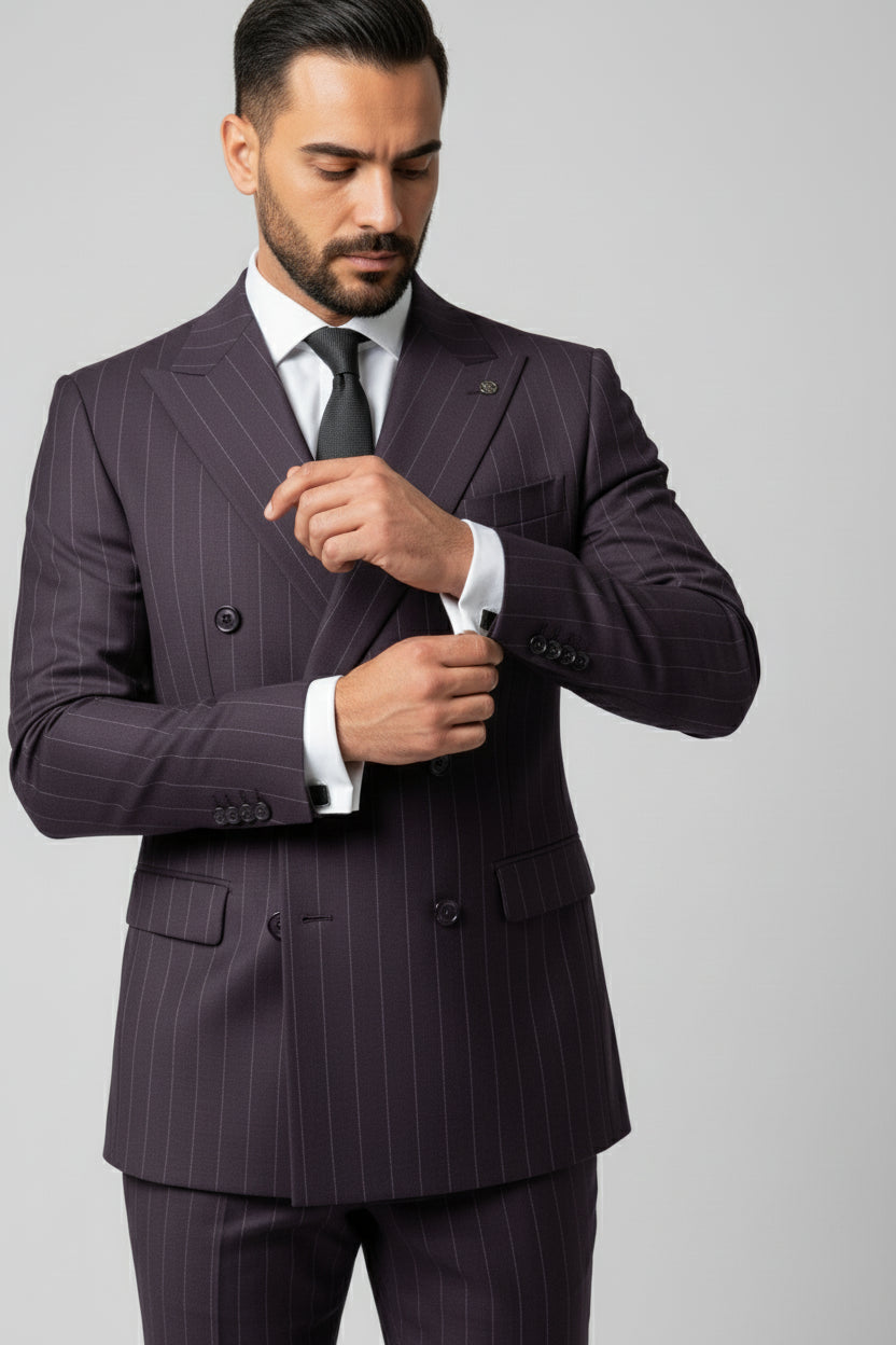 Man adjusting cuffs of maroon pinstripe double-breasted suit for formal event.