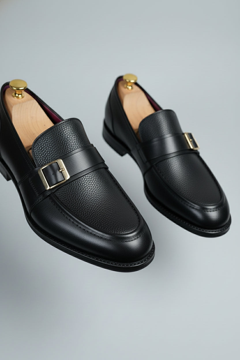 Black leather dress shoes with buckle detail, perfect for formal wear and business occasions.