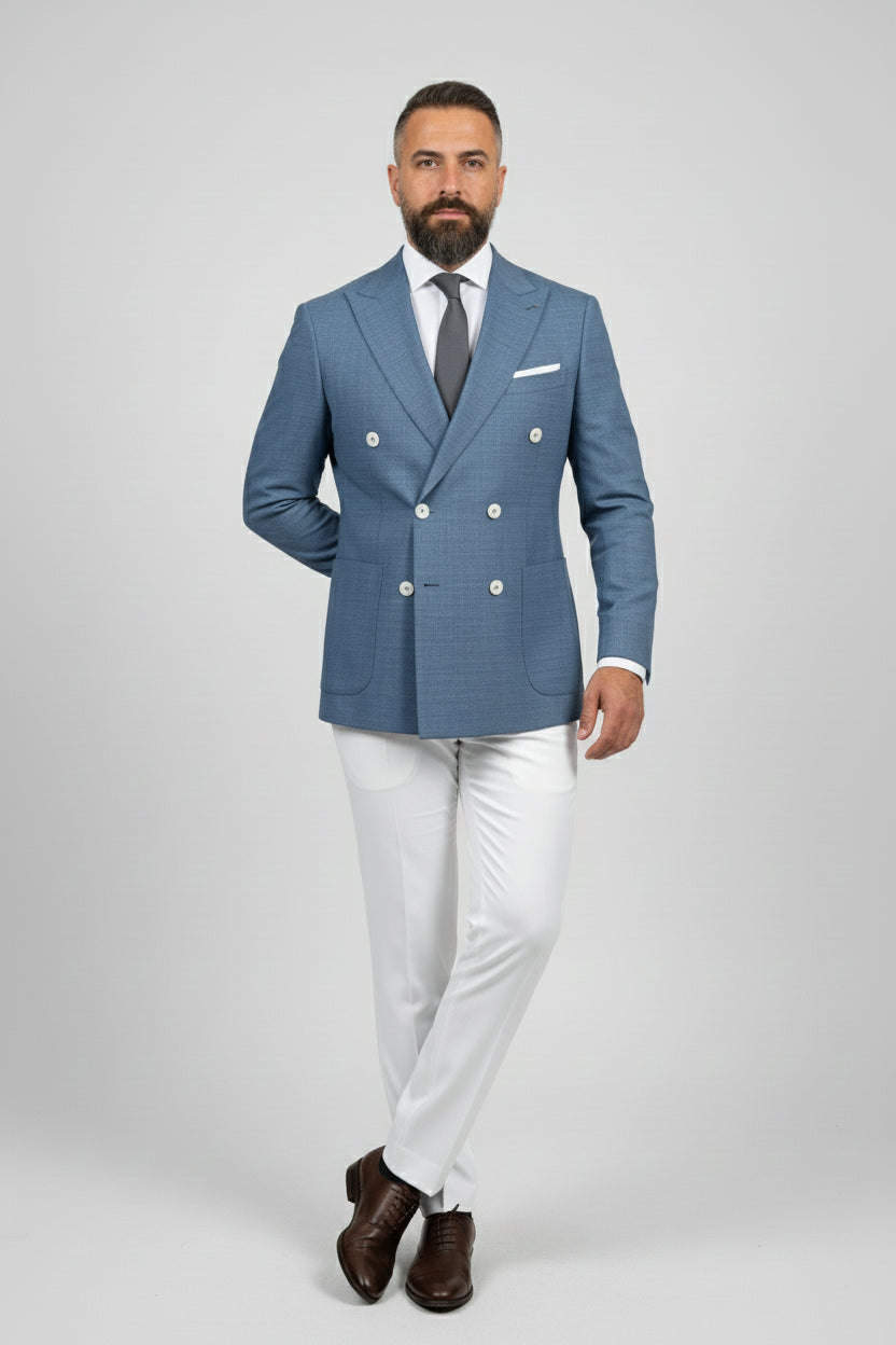 Man in midnight petrol double-breasted suit with white trousers and brown shoes.