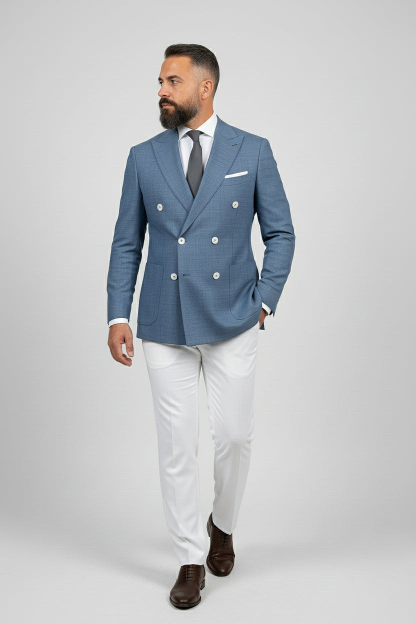 Man wearing midnight petrol double-breasted suit with white tailored trousers.