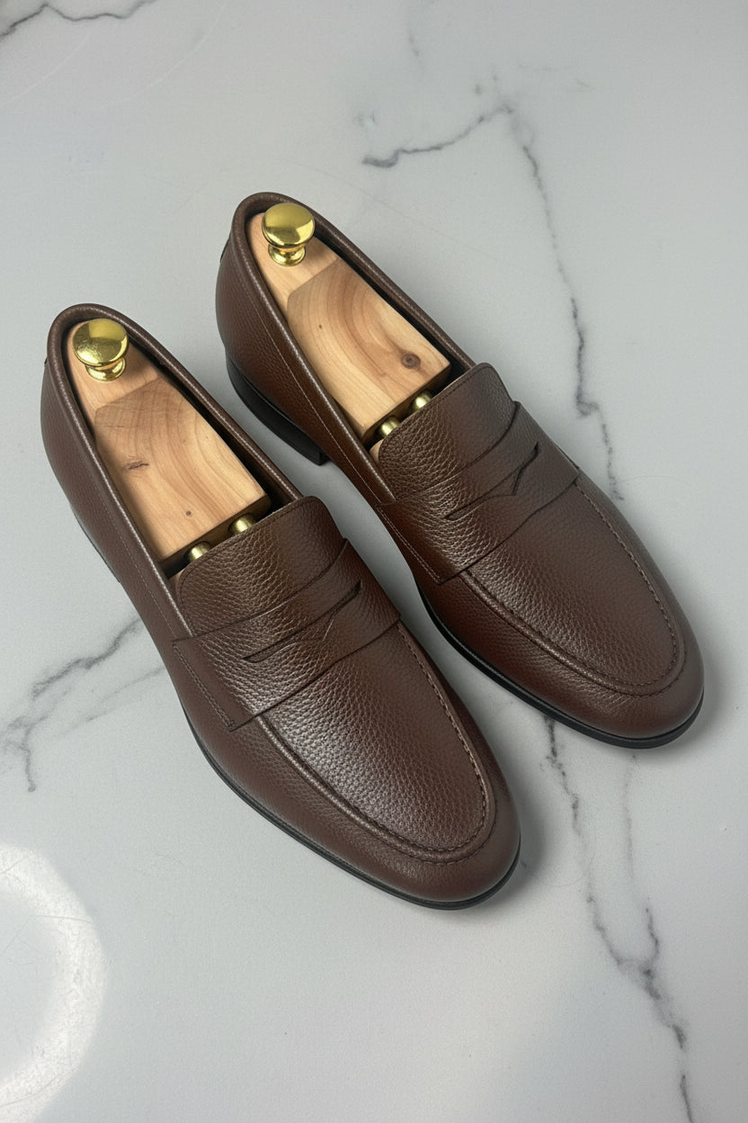 Dark brown leather slip-on loafers with textured finish and standard fit.