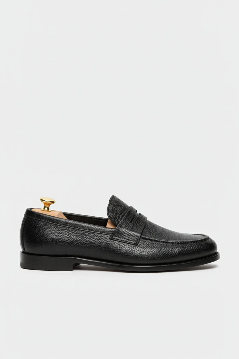 Black textured leather slip-on loafer with elegant design and comfortable fit.