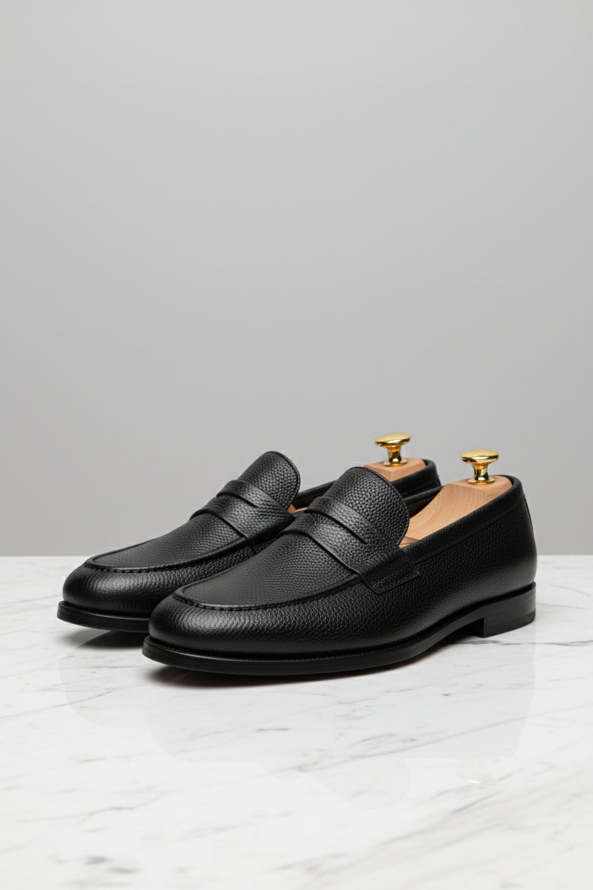 Black textured leather slip-on loafers with stylish design and comfortable fit.