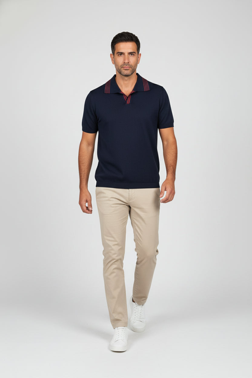 Man wearing navy knit polo with red stripes and short sleeves, paired with khaki pants.