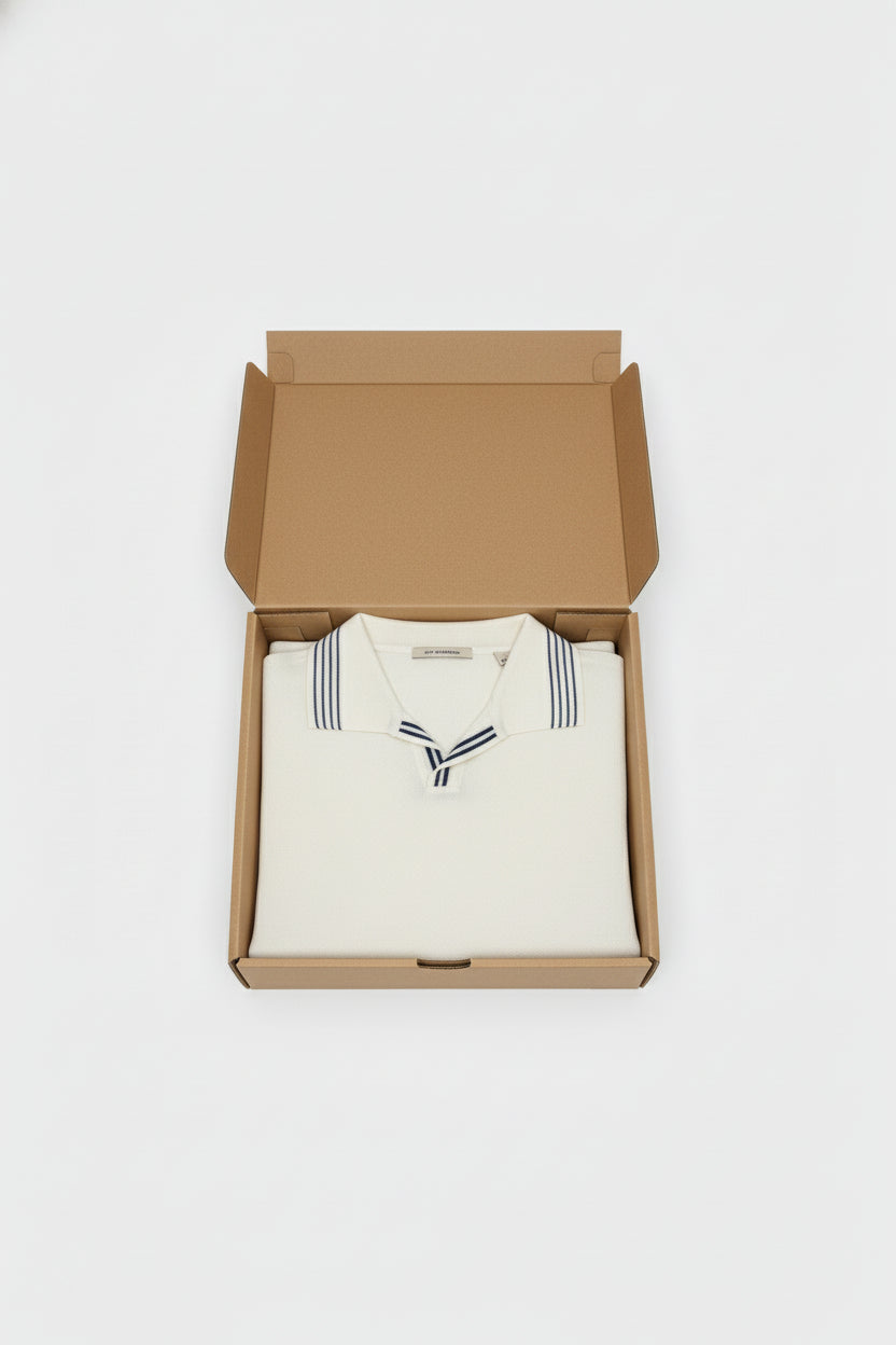White cotton polo with navy stripes, neatly folded in a box.