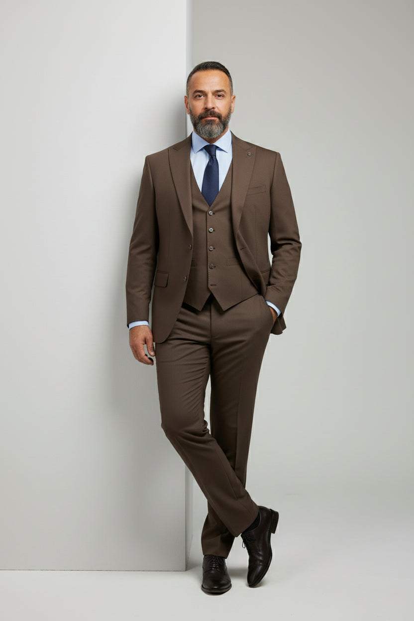 Man wearing tailored brown three-piece suit with vest and tie, ideal for weddings or business.