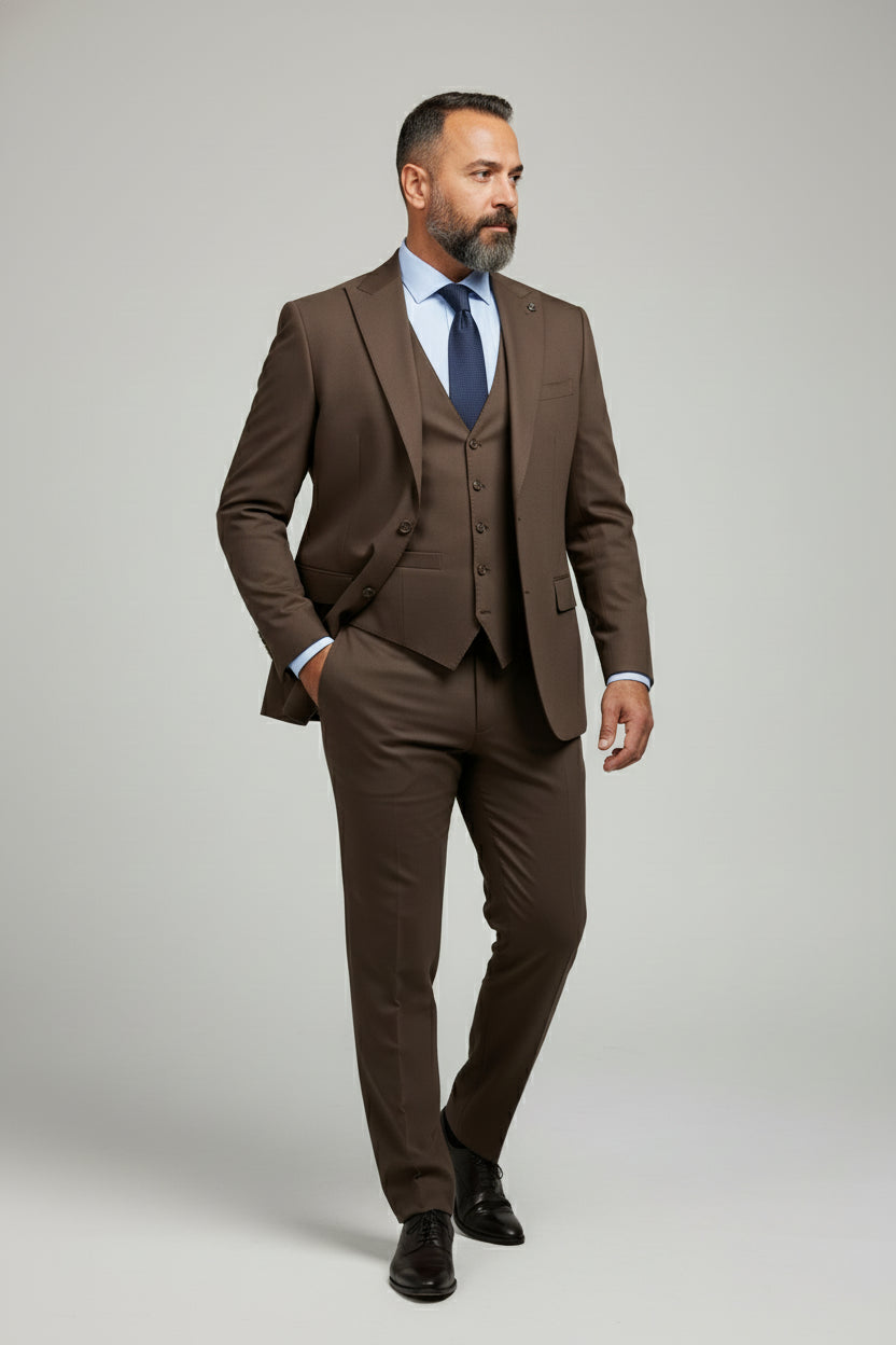 Man wearing tailored brown three-piece suit with waistcoat and blue tie.