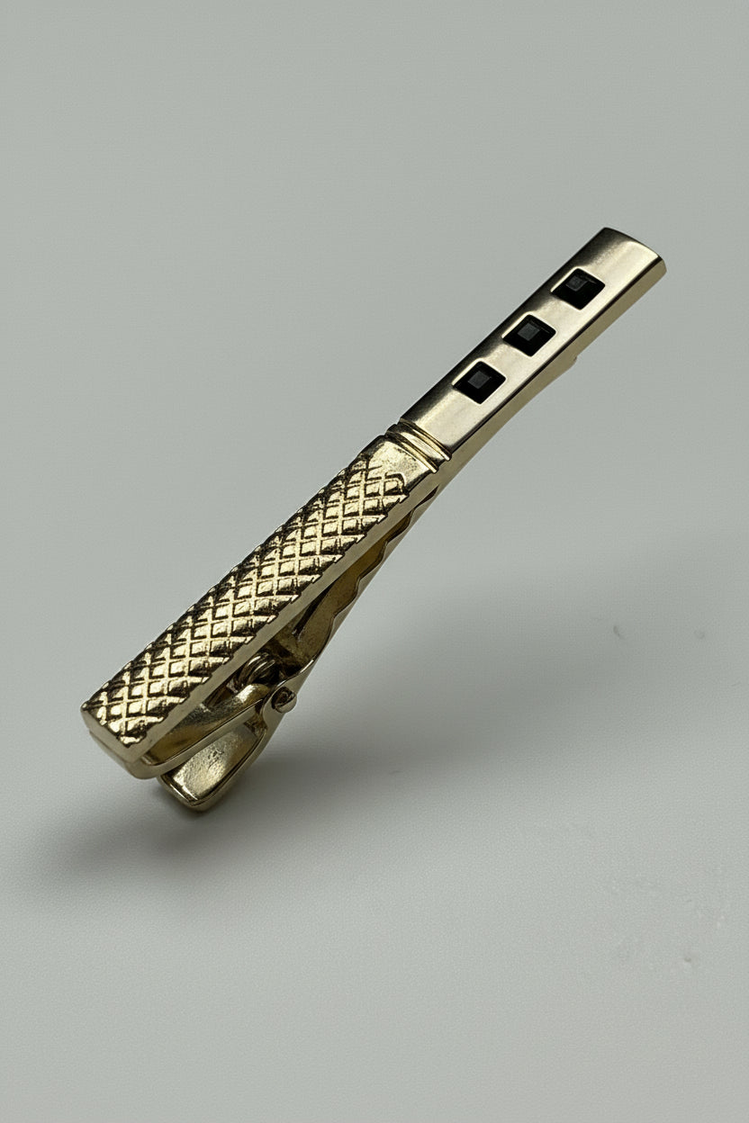 Gold textured tie clip with elegant design, ideal for formal occasions.