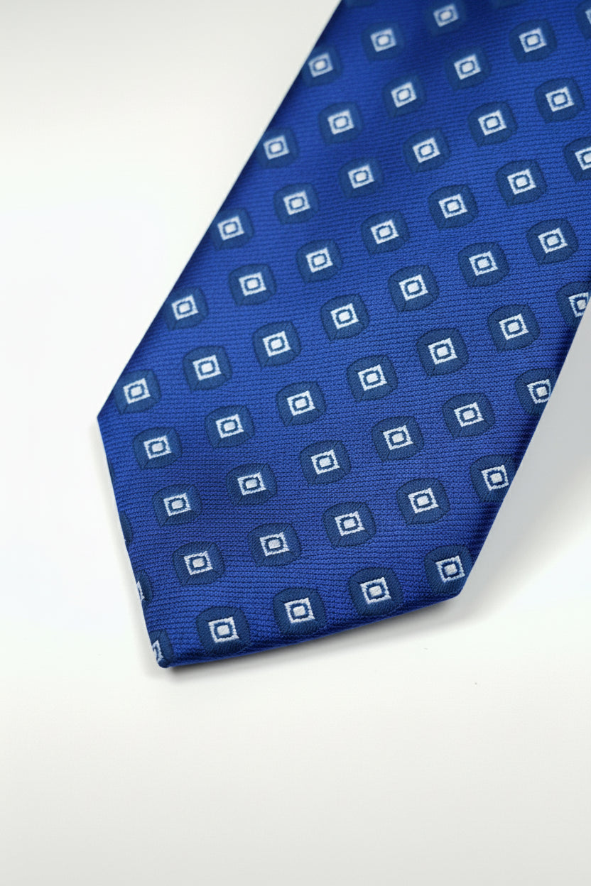 Blue silk tie with patterned squares, perfect for formal wear or business events.