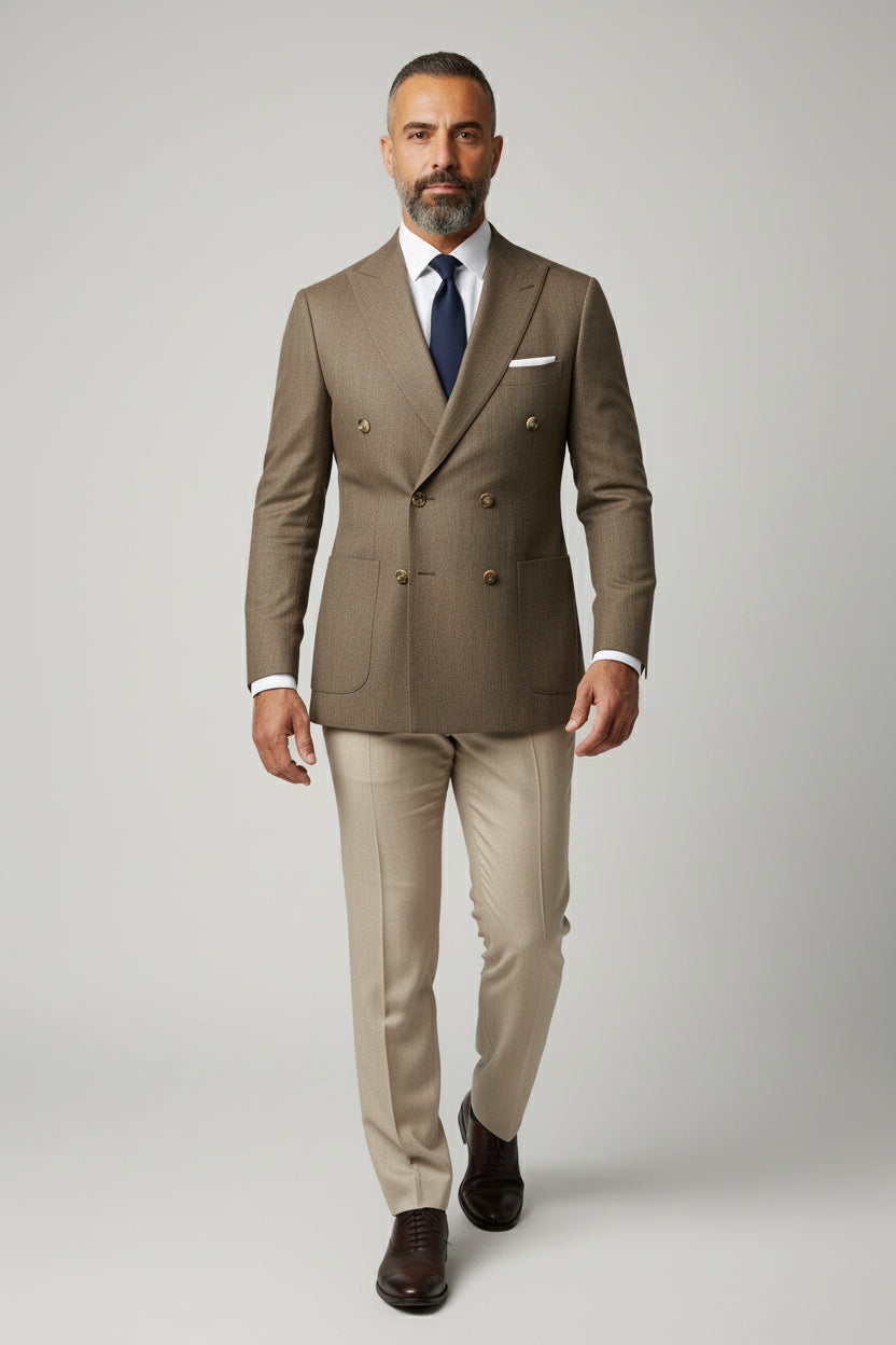 Man wearing brown double-breasted herringbone suit with tailored fit and navy tie.