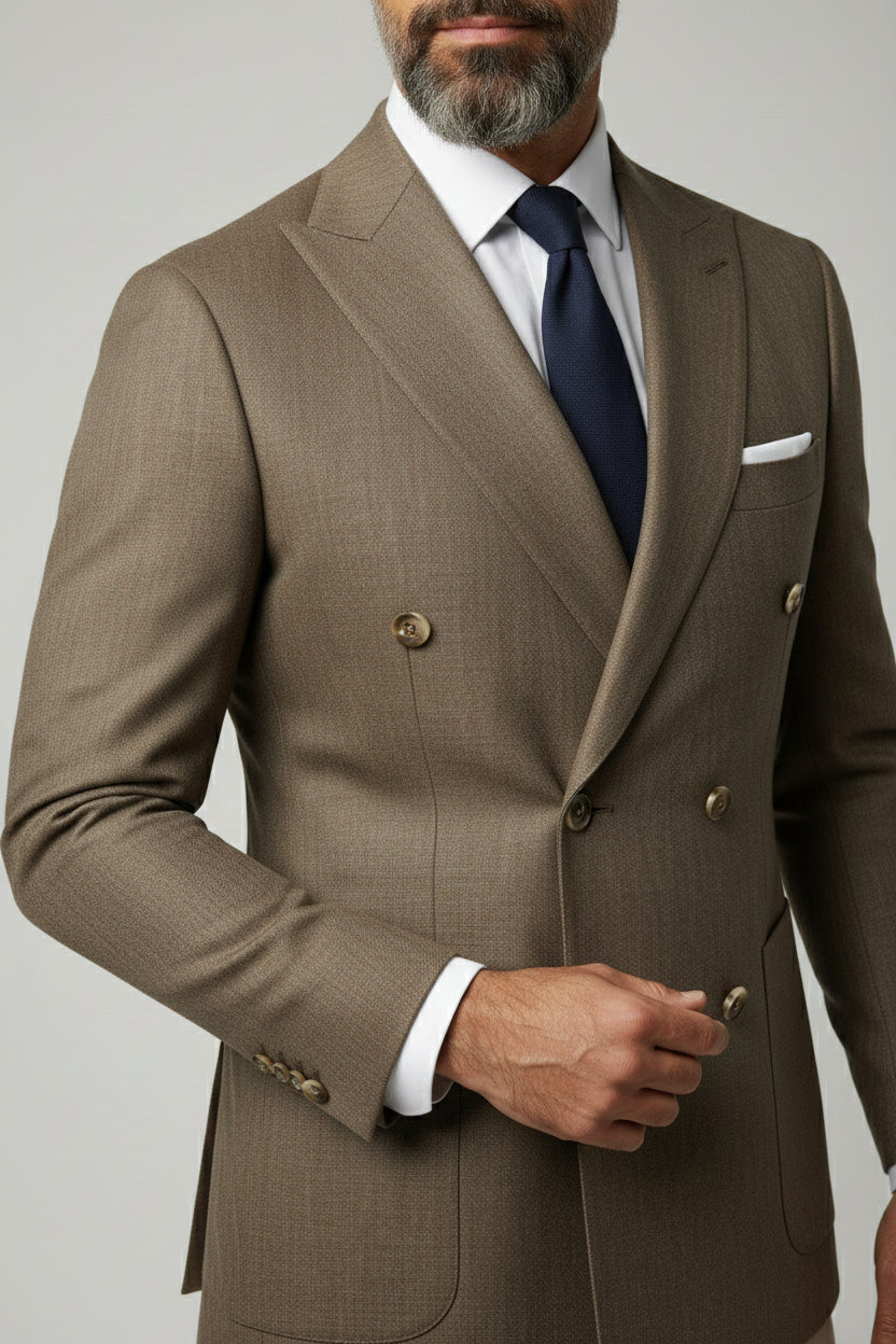 Man wearing brown double-breasted herringbone suit with tailored fit and navy tie.
