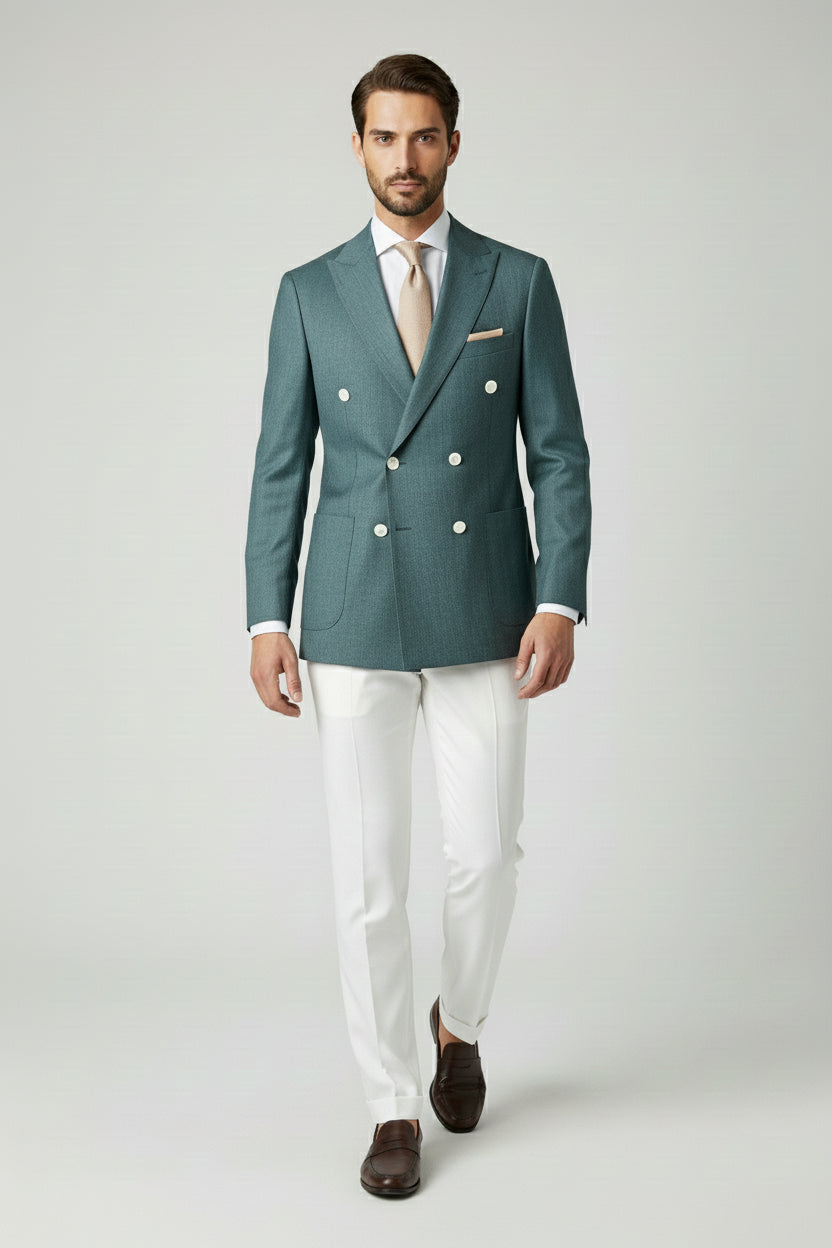 Man wearing deep teal double-breasted suit jacket with white tailored pants.