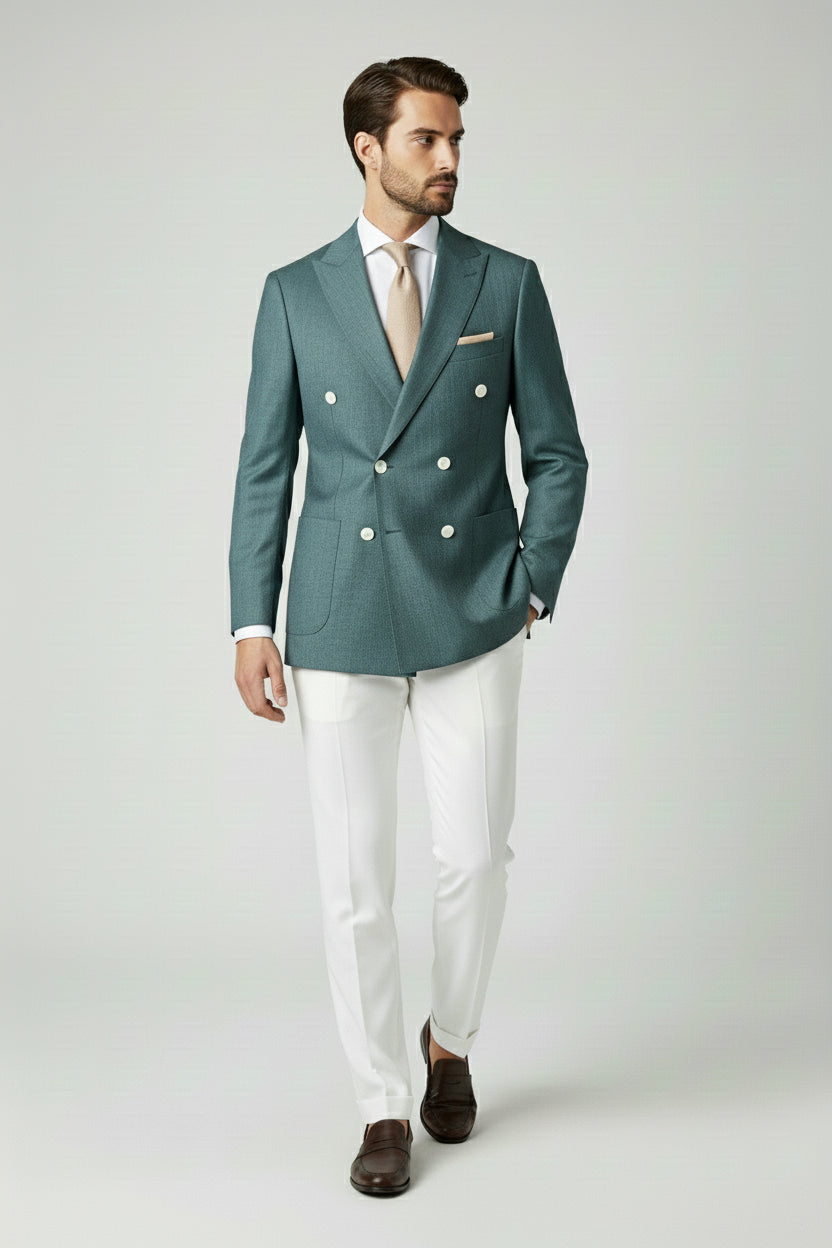 Man in deep teal double-breasted suit jacket and white tailored pants.