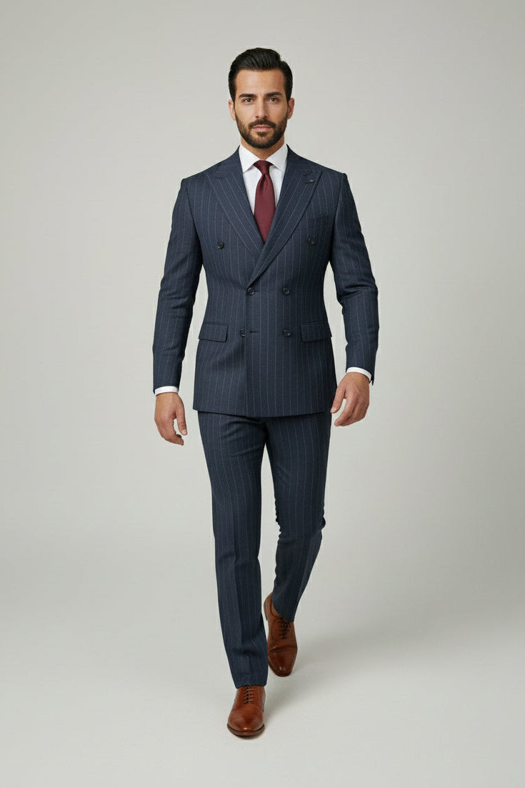 Man wearing navy pinstripe double-breasted suit with tailored fit and brown shoes.