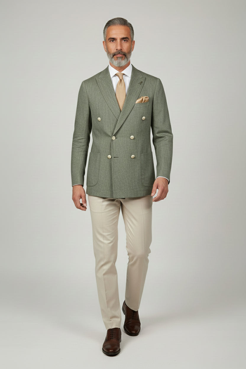 Man wearing sage green double-breasted suit with beige tailored trousers and brown shoes.
