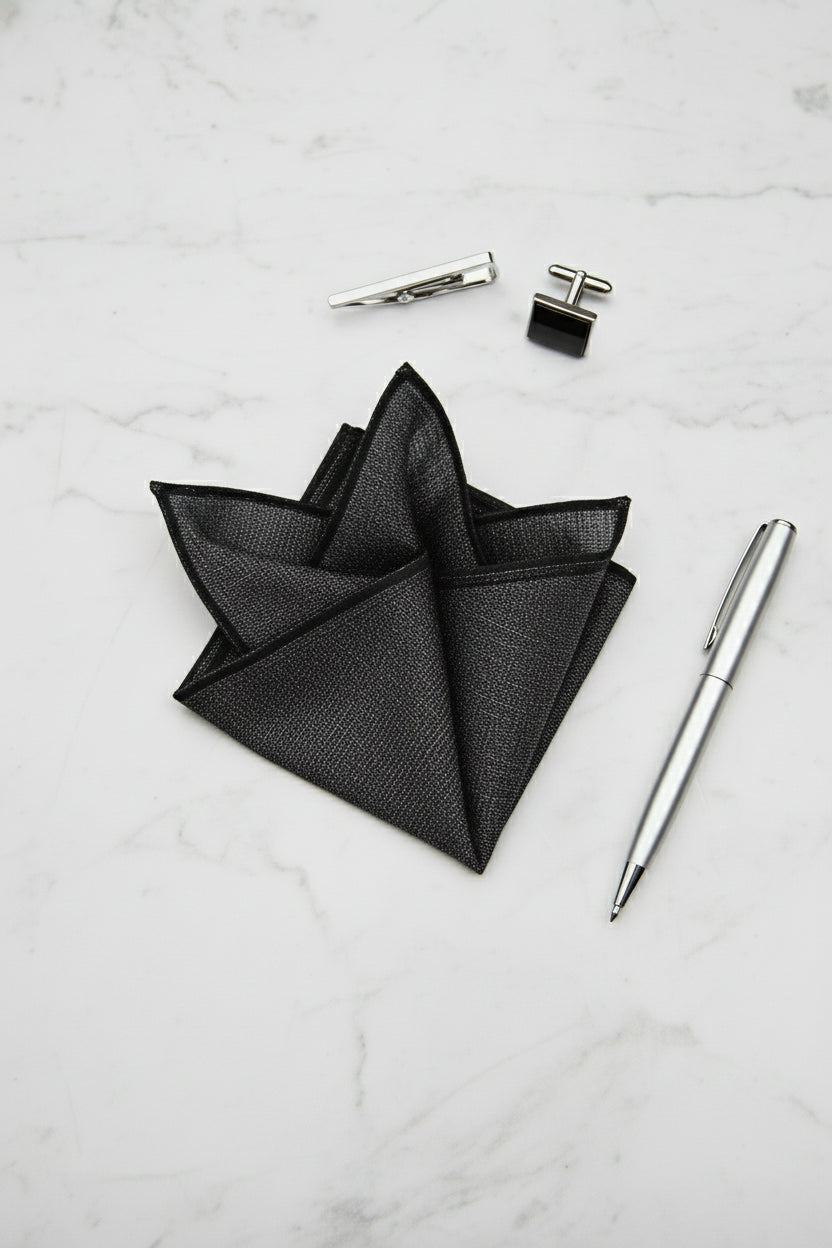 Black textured silk pocket square elegantly folded, perfect for formal wear and weddings.