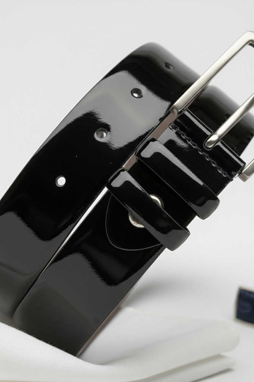 Black patent leather dress belt with adjustable silver buckle and polished finish.