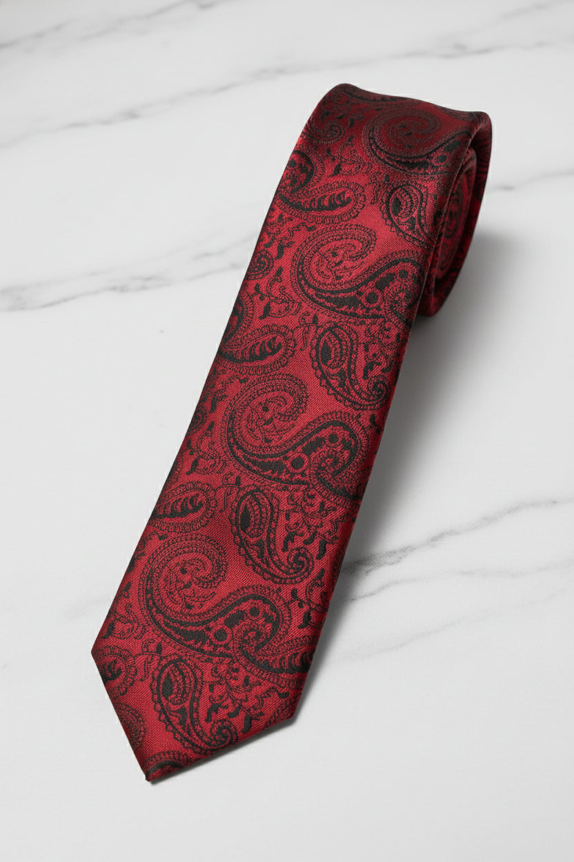 Red paisley silk tie with intricate black patterns, ideal for formal occasions.