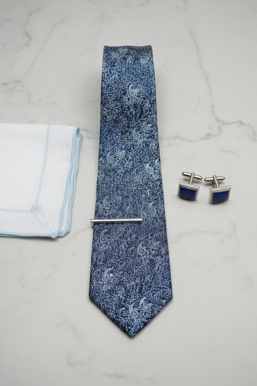 Navy paisley pattern silk tie paired with cufflinks and pocket square.