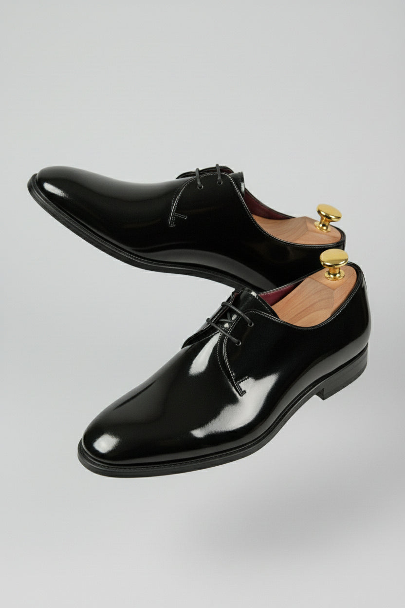 Black patent leather Oxford shoes with lace-up design, perfect for formal occasions.