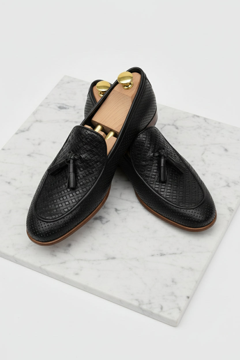 Black textured woven loafers with tassels, ideal for casual or formal wear.