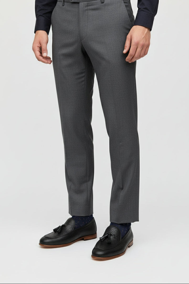 Man wearing black textured woven loafers paired with grey dress pants.
