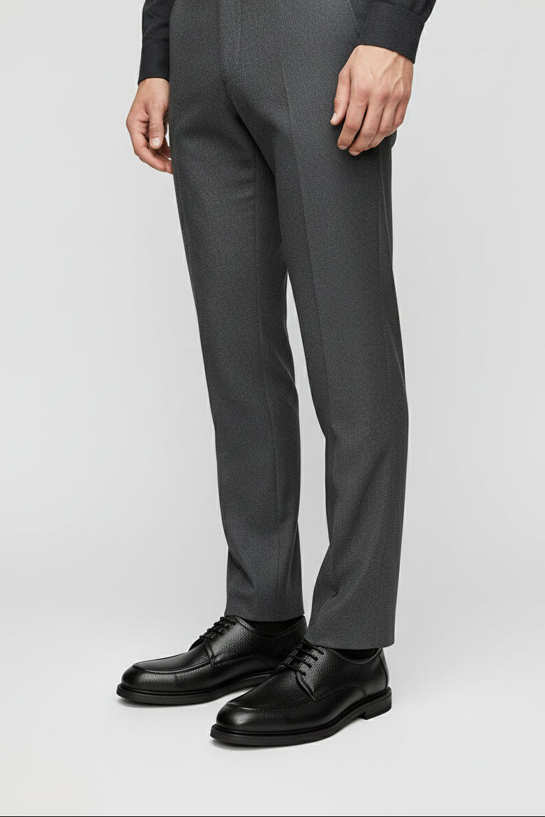 Man wearing black leather Oxford shoes with grey tailored pants for formal occasions.