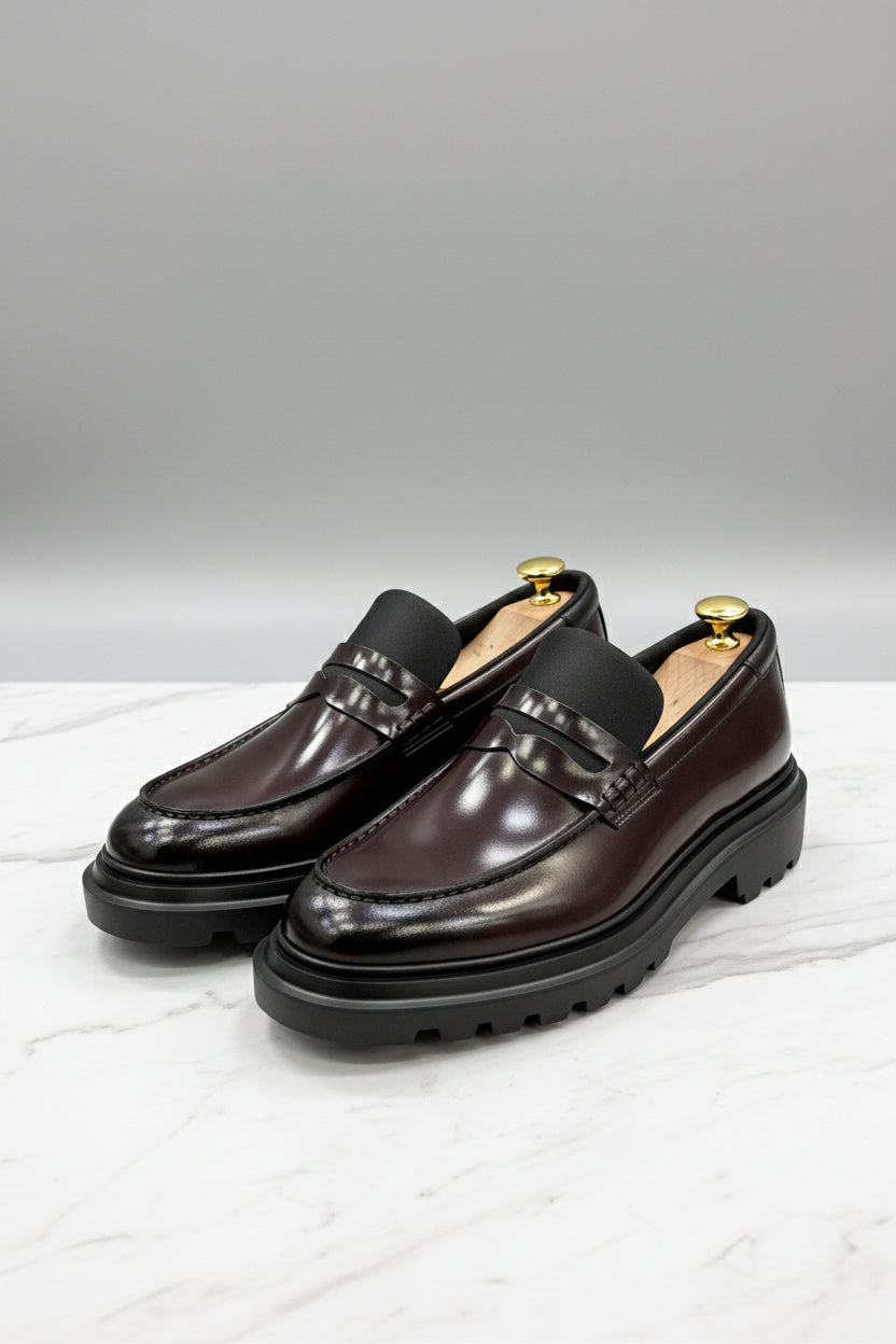 Burgundy leather slip-on loafers with stylish detailing and comfortable soles.