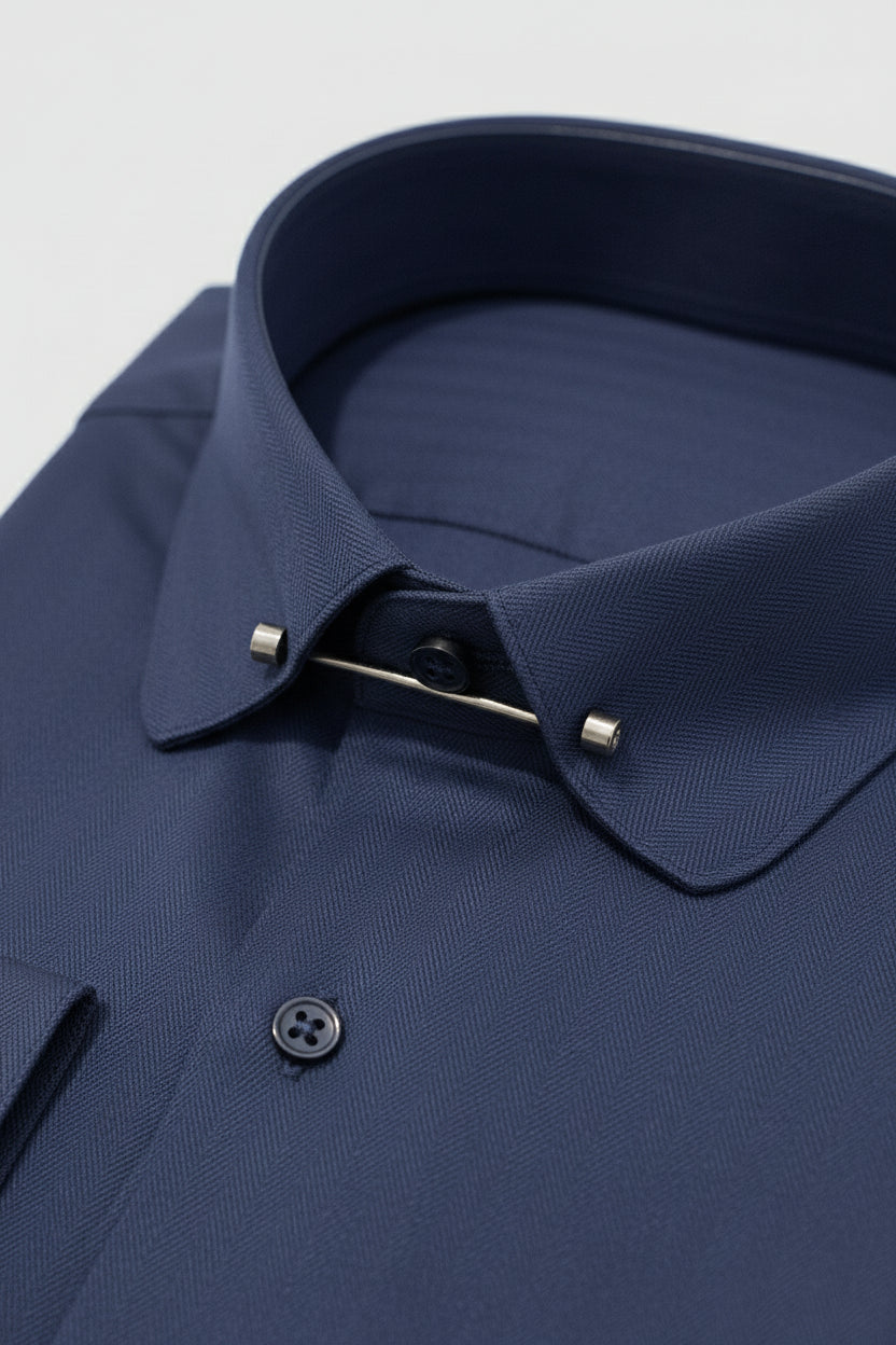 Navy herringbone dress shirt featuring a stylish collar bar and button detail.