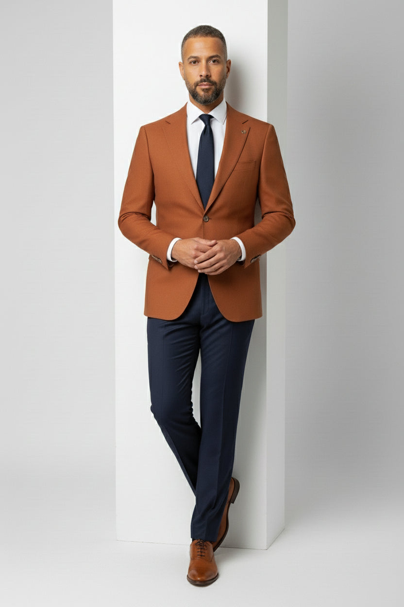 Man in orange peak lapel suit jacket paired with navy trousers and tie.
