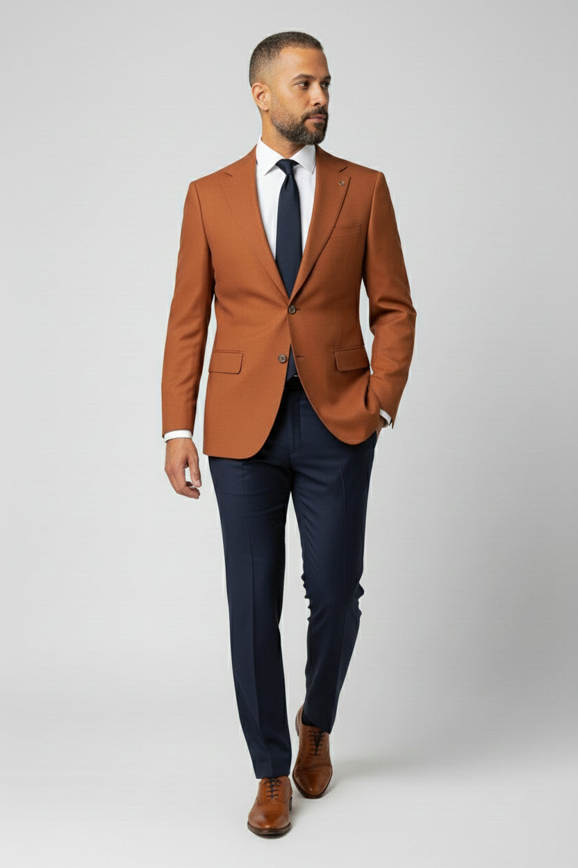 Man wearing orange and navy combination suit with peak lapels and modern fit.