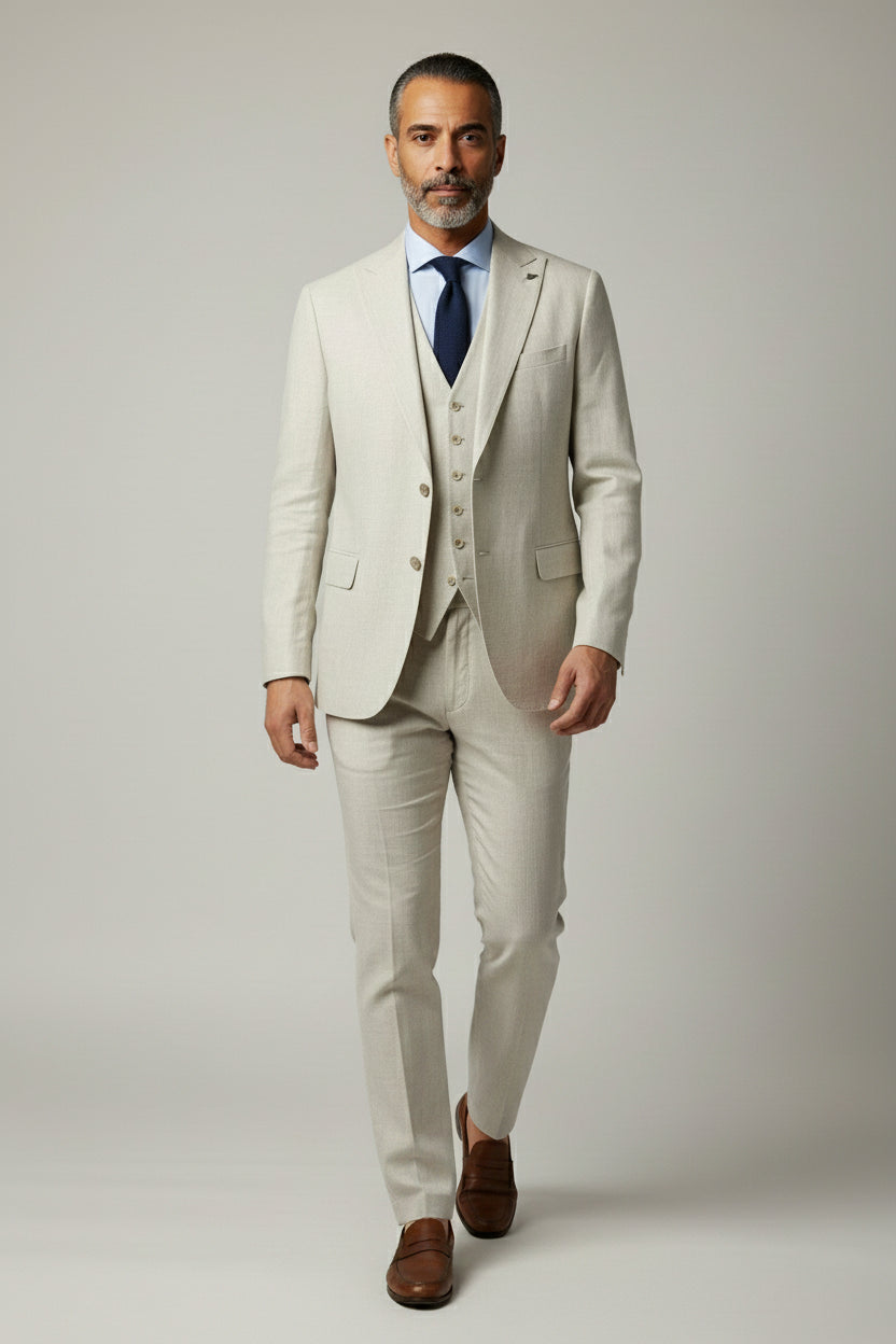 Man wearing beige three-piece suit with notched lapel, ideal for summer weddings.