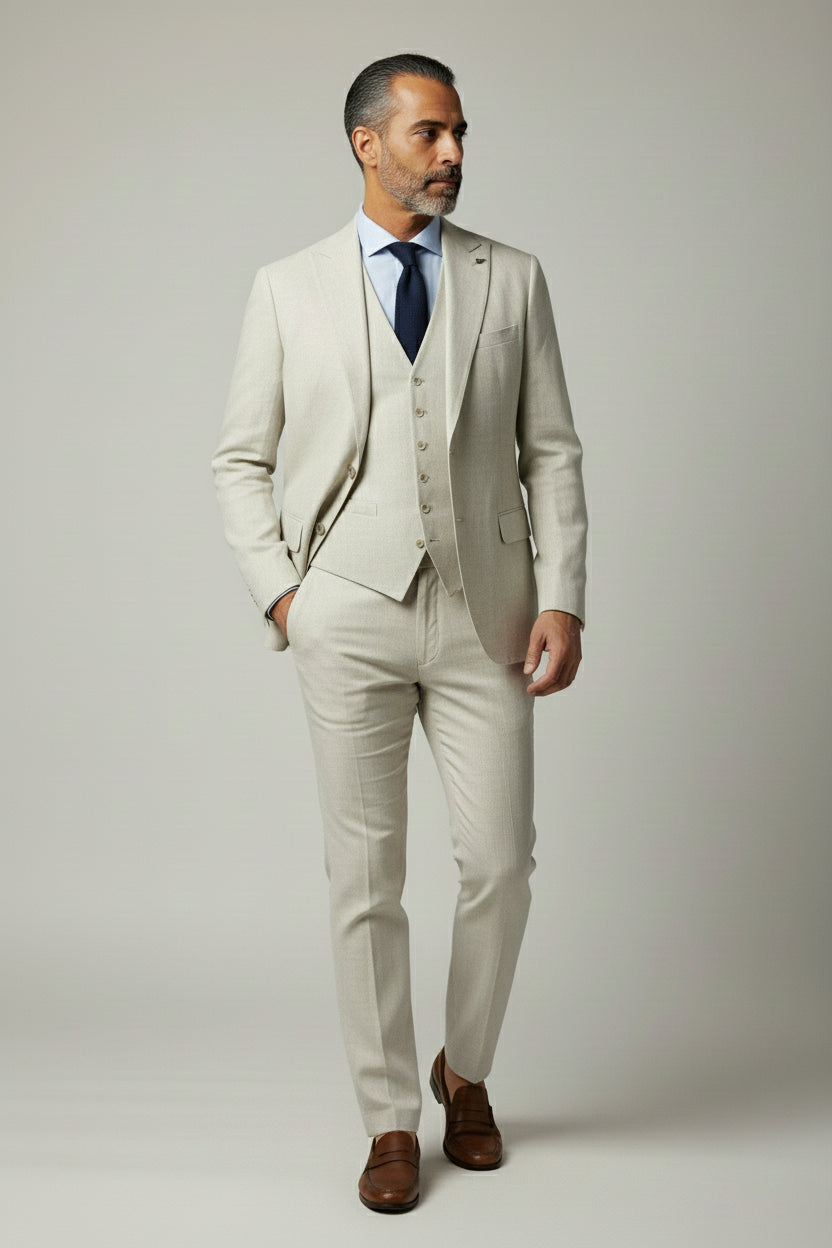 Man wearing beige three-piece suit with notched lapel, perfect for summer weddings.
