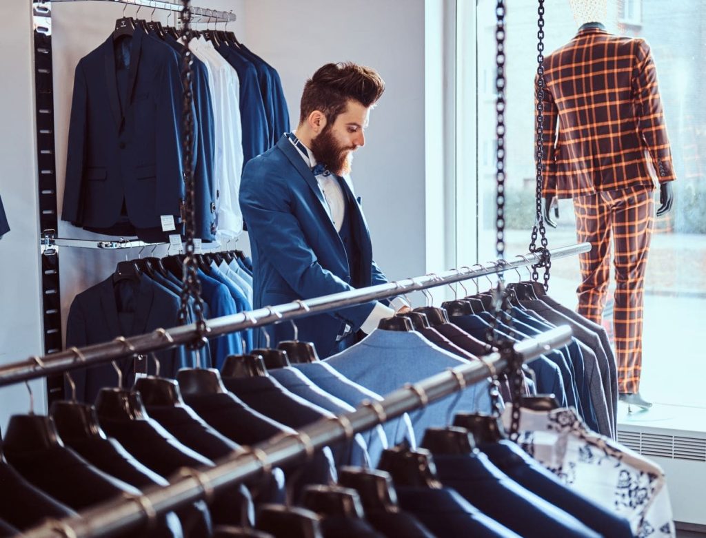 bearded shop assistant dressed in blue elegant sui 8GQUFRY